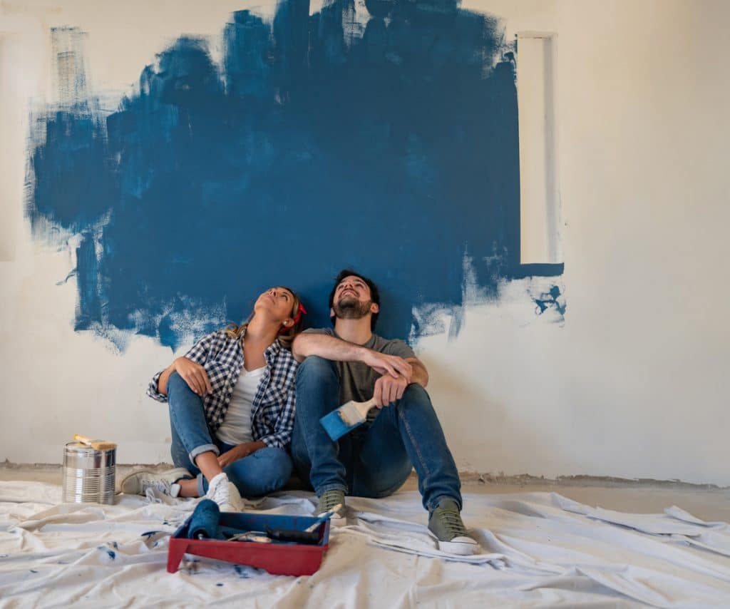 Thoughtful couple painting their house